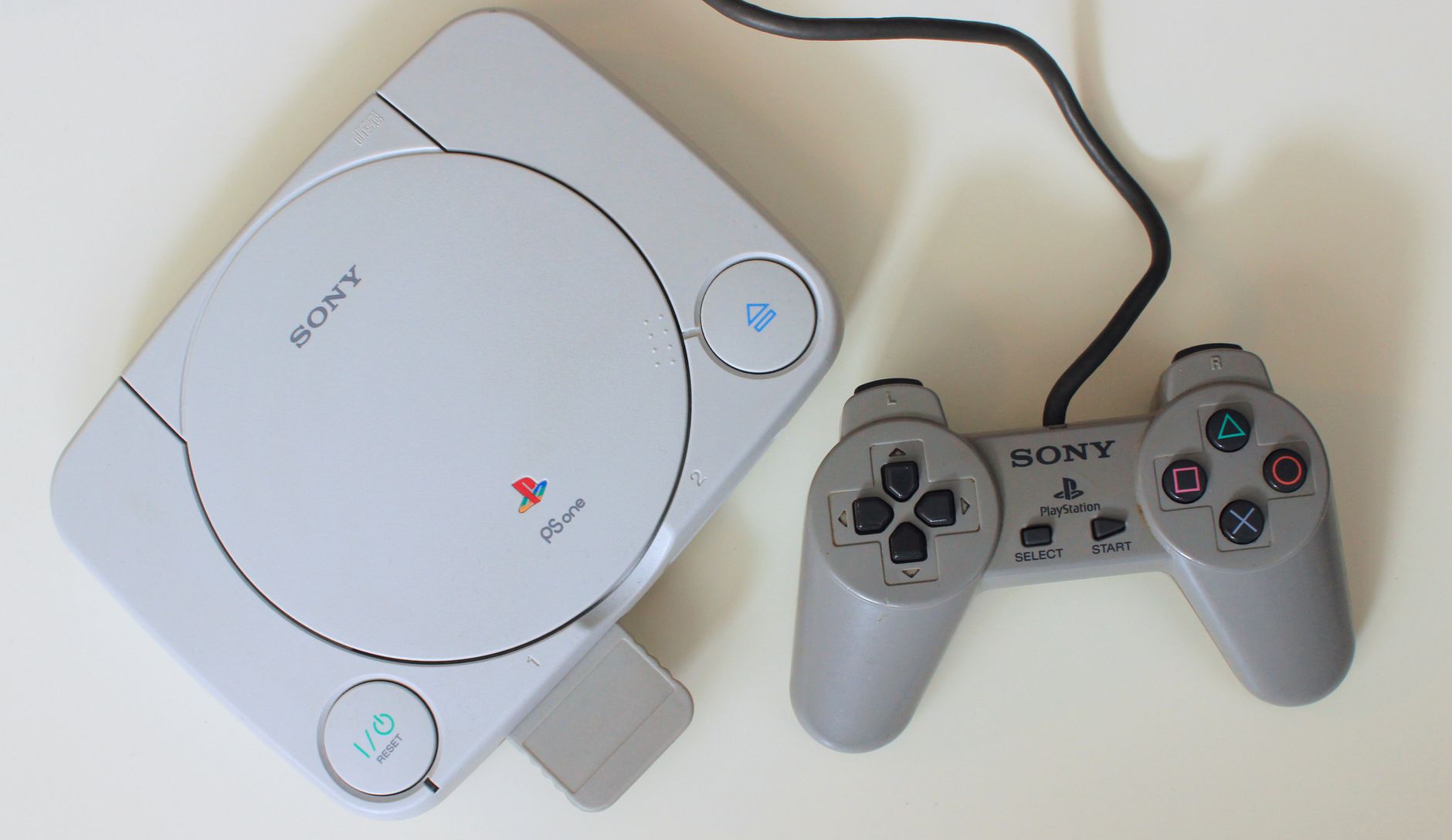 Close-up view of a retro Sony PlayStation One console with controller, ideal for game nostalgia enthusiasts.